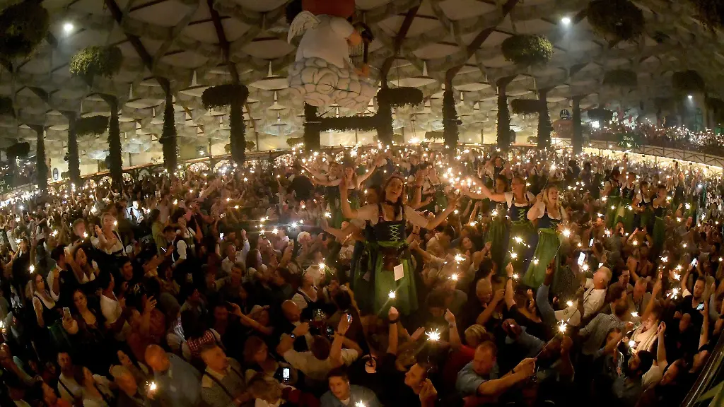 Bedienungen-und-Gaeste-feiern-mit-Wunderkerzen-beim-traditionellen-Kehraus-im-Hofbraeuzelt-den-Abschluss-der-Wiesn