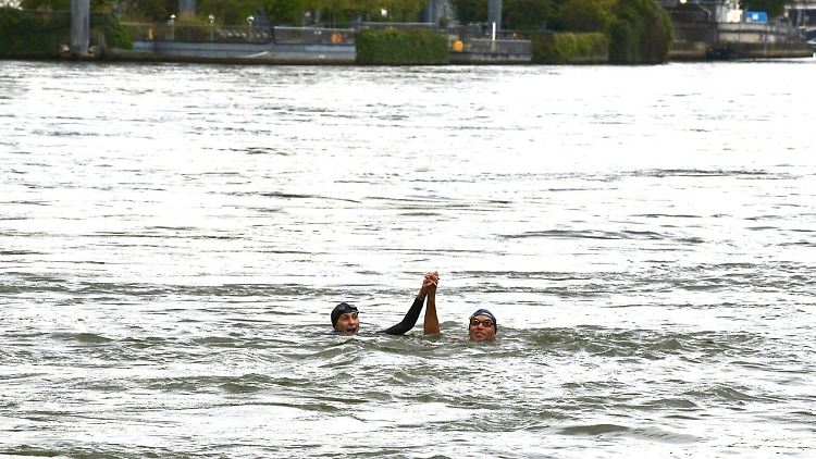 Amélie Oudéa-Castéra (l.) schwamm gemeinsam mit dem Triathleten und Goldmedaillengewinner der Paralympics 2020 in Tokio, Alexis Hanquinquant.