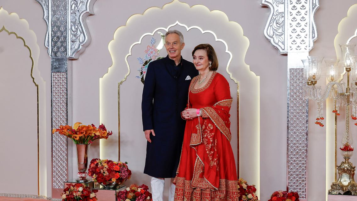 Auch Politprominenz ist zugegen: Tony Blair und seine Frau Cherie folgen etwas legerer als Kardashian lokalen Kleidungsgepflogenheiten.