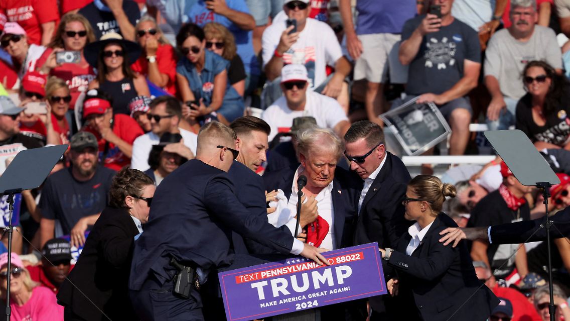 Sicherheitsbeamte bilden einen schützenden Kreis um Donald Trump.