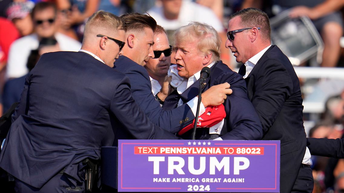 Vor der Faust der Stärke ist die Angst in Trumps Gesicht zu sehen - umringt ist er von Spezial-Agenten.