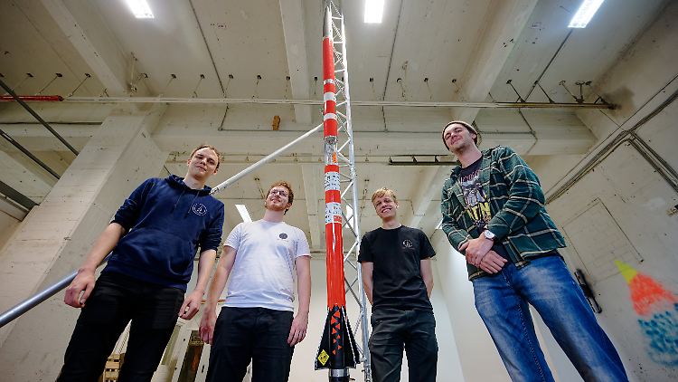 Die Studenten Florian Schuler (l-r), Lukas Freiheit, Johann Schepke und Lukas Laumann vom Space Team Aachen neben ihrer Rakete.