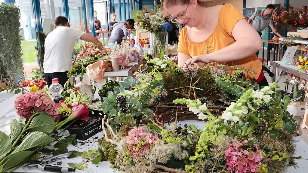 Diana-Troeger-vorne-von-Rosenrot-aus-Halle-Saale-arbeitet-an-einem-Gesteck