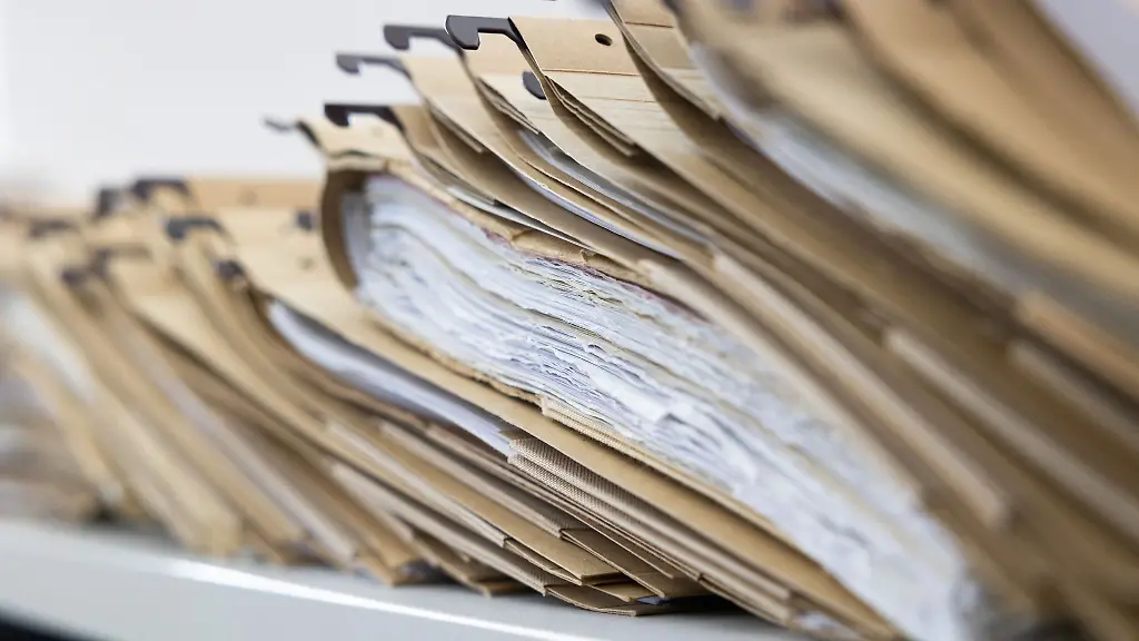 Zahlreiche-Akten-sind-auf-einem-Schreibtisch-ausgelegt