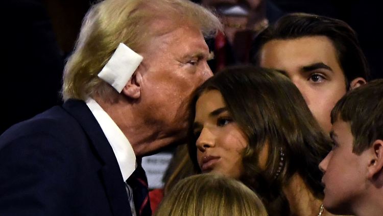 Donald Trump flüstert seiner Enkelin Kai etwas ins Ohr.
