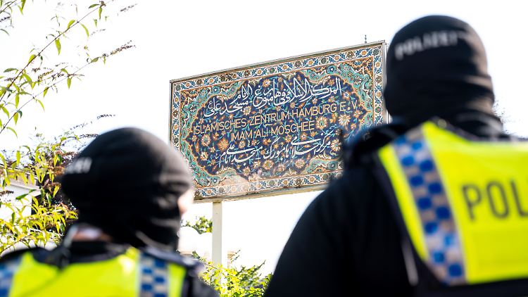 Einsatzkräfte der Polizei stehen während der Razzia auf dem Gelände des Islamischen Zentrums Hamburg mit der Blaue Moschee.
