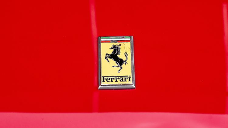 Ein rotes Auto mit einem schwarzen Pferd auf gelbem Grund: So sieht ein Ferrari aus.