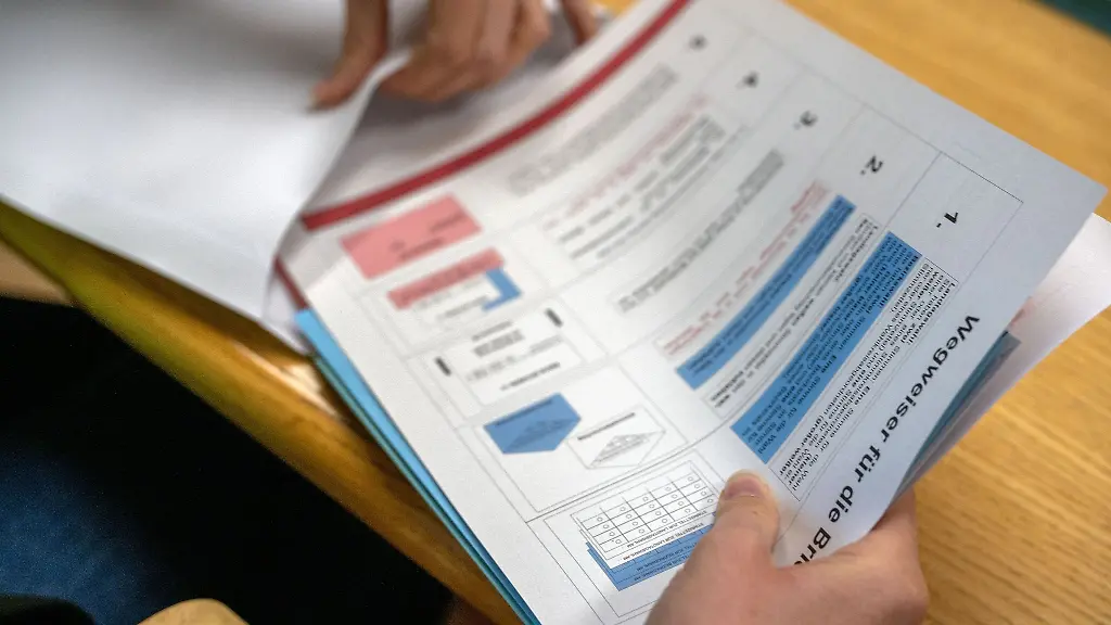 Eine-Verwaltungsmitarbeiterin-steckt-Unterlagen-fuer-die-Briefwahl-in-einen-Umschlag