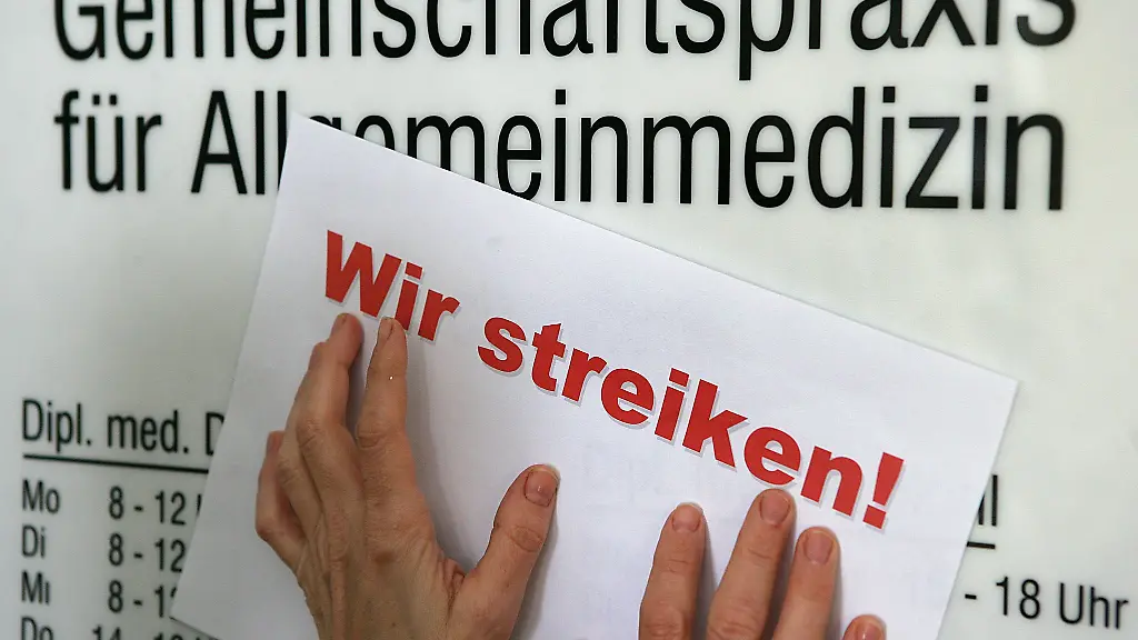 Ein-Zettel-mit-der-Aufschrift-Wir-streiken-am-Eingang-zur-Praxis