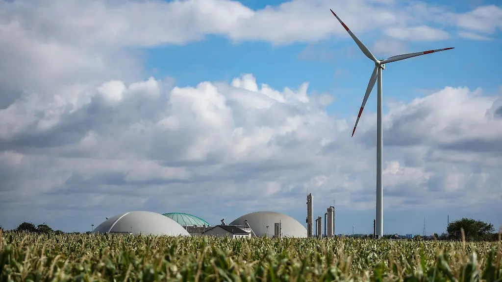 Ein-Windrad-dreht-sich-neben-einer-Biogasanlage-hinter-einem-Maisfeld-westlich-von-Halle-Saale