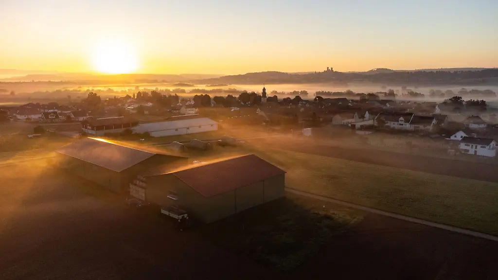 Beim-Sonnenaufgang-zieht-Nebel-ueber-die-Stadt-Muenzenberg-Luftnahme-mit-einer-Drohne
