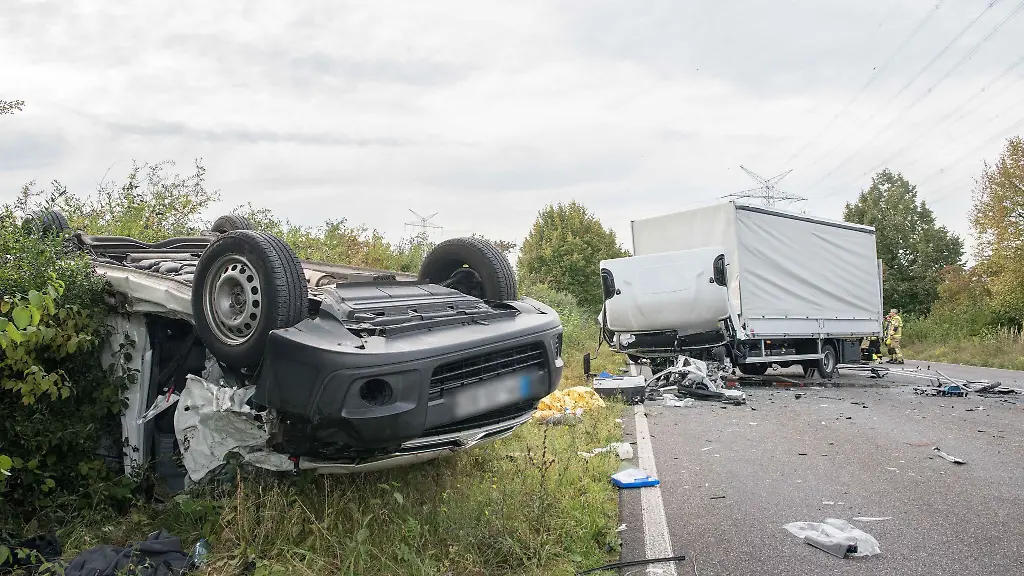 Nach-einem-Verkehrsunfall-sind-ein-voellig-zerstoerter-LKW-und-ein-auf-dem-Dach-liegender-massiv-beschaedigter-Transporter-zu-sehen