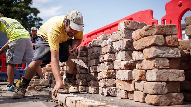 Arbeiter bauen eine Mauer um die angegriffene Moschee in Southport wieder auf. 