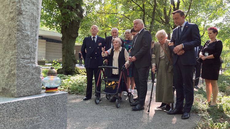 Wanda Traczyk-Stawska (3. v l), Teilnehmerin des Warschauer Aufstands 1944, zeigt Bundespräsident Frank-Walter Steinmeier einen Gedenkstein auf dem Friedhof für die toten Aufständischen. 