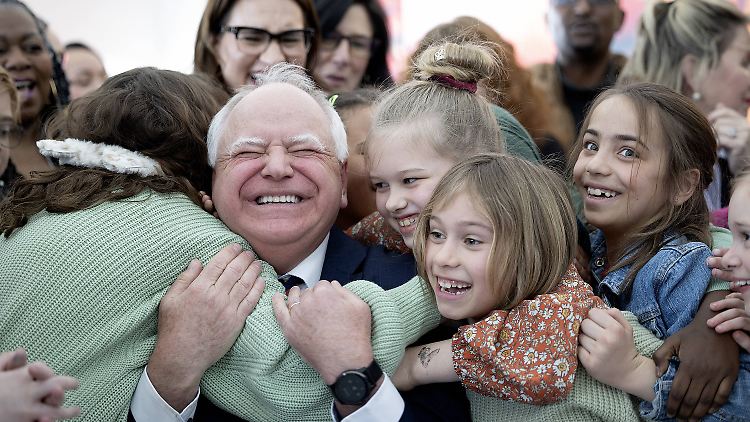 Tim Walz wird von den Schülerinnen und Schülern der Webster-Grundschule umarmt. Im März hatte er ein Gesetz unterzeichnet, das kostenlose Schulmahlzeiten garantiert.