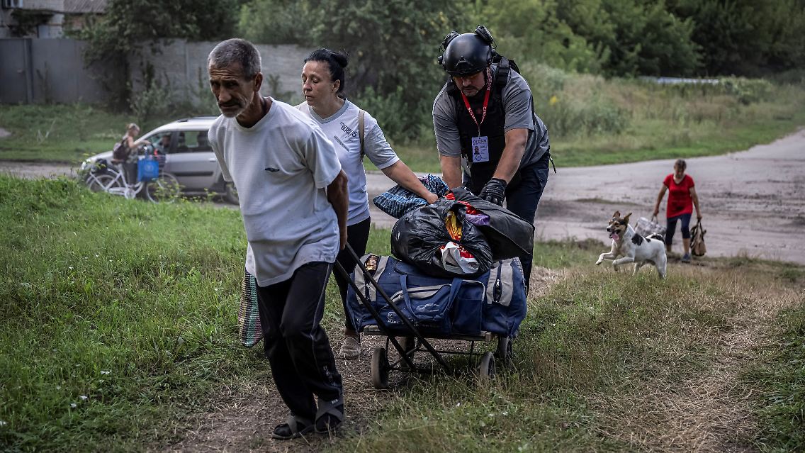 Ein Freiwilliger hilft den Bewohnern eines Dorfes in der ukrainischen Grenzregion Sumy, ihre Habseligkeiten zu transportieren.