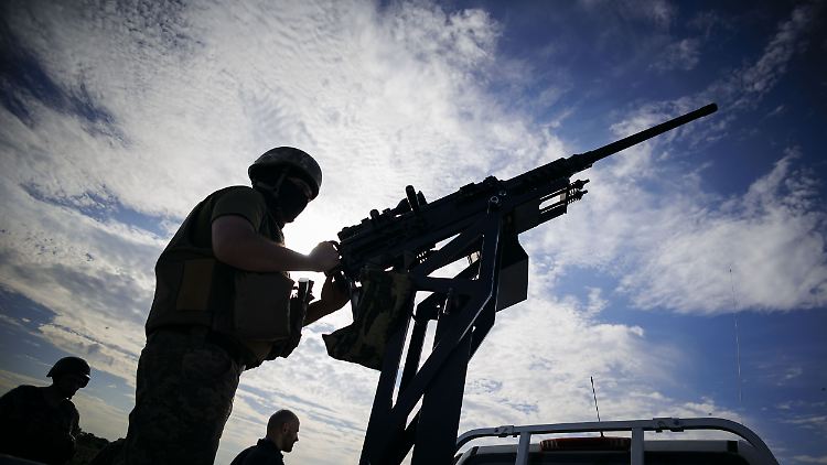 Ein Soldat einer Einheit der Mobilen Luftverteidigung steht an einem Maschinengewehr, welches auf einem Pickup montiert ist. 