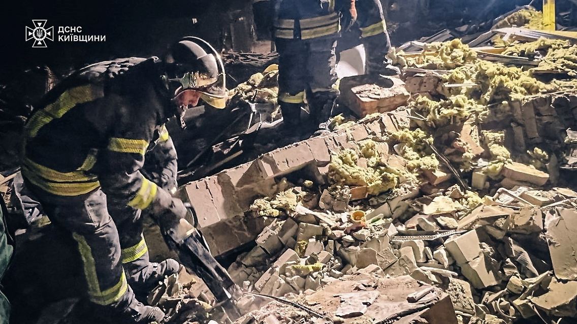 Nach dem Einschlag einer russischen Drohne in ein Wohnhaus in der Nähe von Kiew räumen Rettunsgkräfte die Trümmerteile weg.