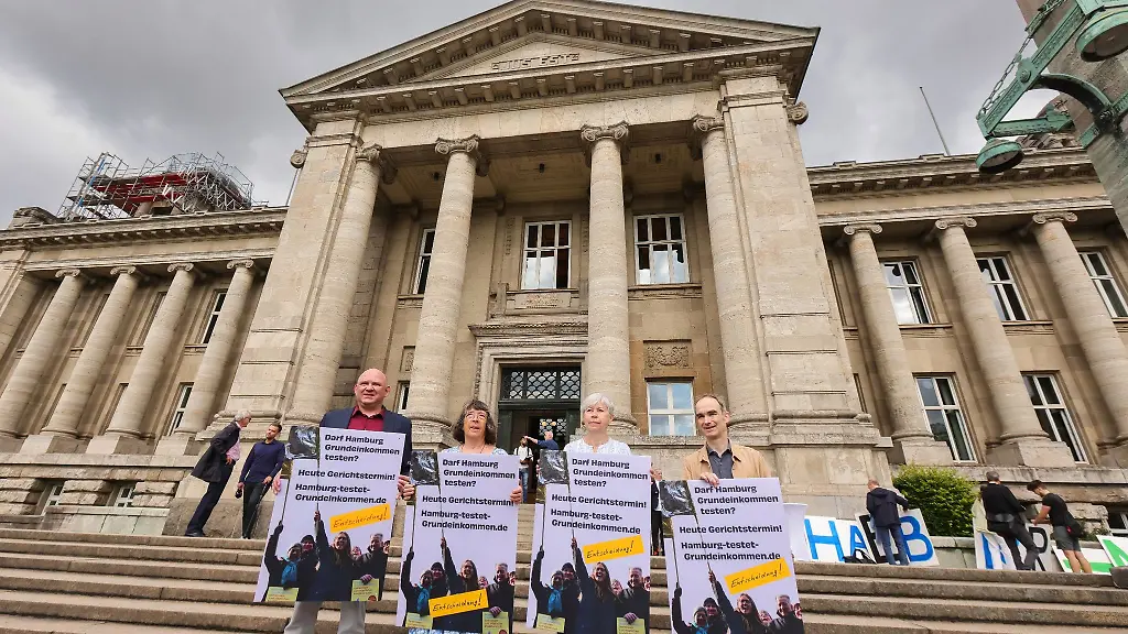 Unterstuetzer-der-Volksinitiative-Hamburg-soll-Grundeinkommen-testen-stehen-vor-dem-Oberlandesgericht