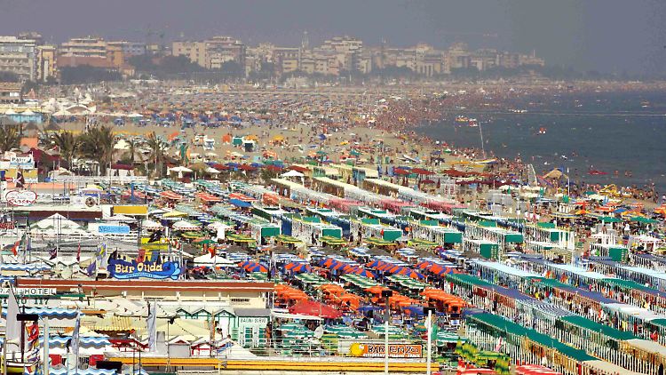 Liegen und Sonnenschirme so weit das Auge reicht: Der überfüllte Strand der italienischen Badeorte Riccione und Rimini an der Adria.