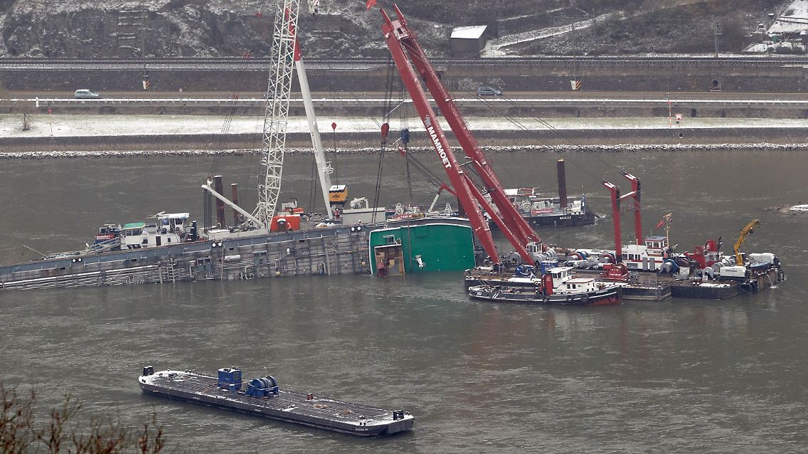 Ein Schiff passiert rheinabwärts den gekenterten Säuretanker.