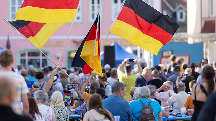 Zuschauer schwenken Deutschlandfahnen beim Wahlkampf der AfD Thüringen auf einem Marktplatz. Am 1. September wird dort ein neuer Landtag gewählt.