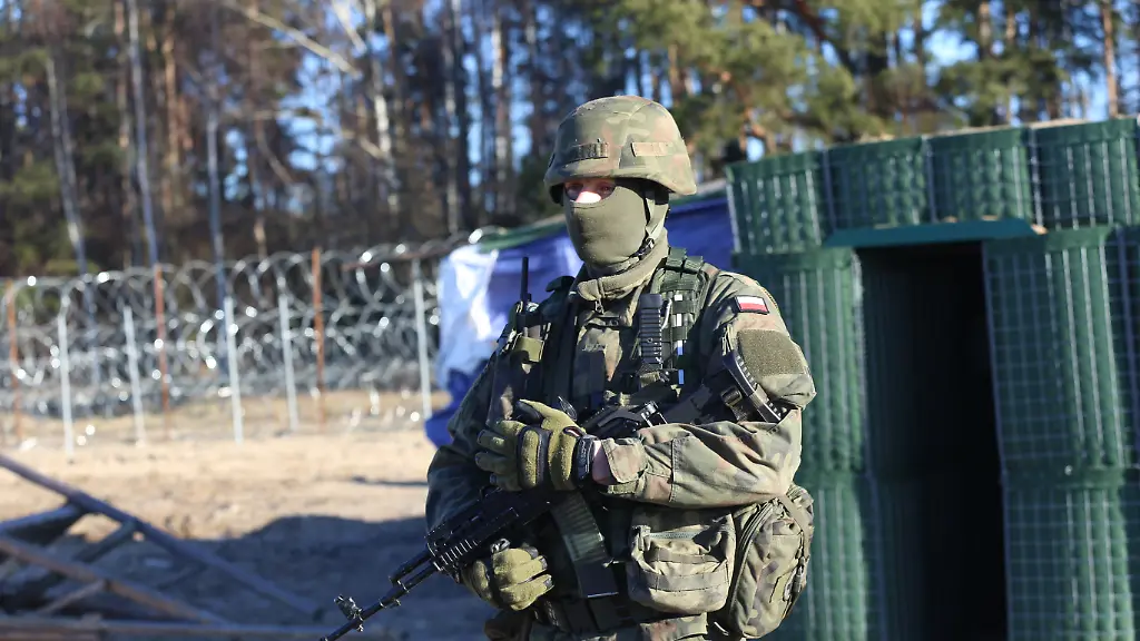 Ein-polnischer-Soldat-bewacht-Grenzanlagen-an-der-Sperrzone-von-Polens-Grenze-zu-Belarus-Die-PiS-ist-fuer-eine-harte-Fluechtlingspolitik-bekannt