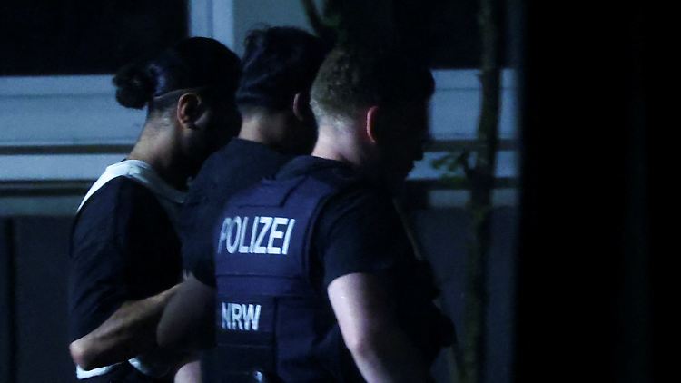 Die Polizei führt in der Nacht einen Tatverdächtigen ab.
