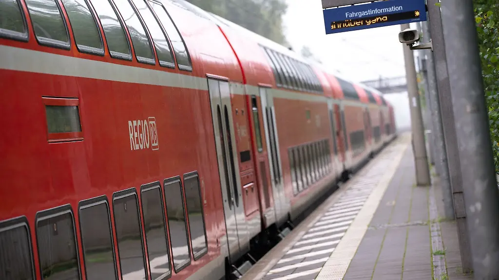 Ein-doppelstoeckiger-Regionalzug-der-Deutschen-Bahn-faehrt-durch-einen-Bahnhof