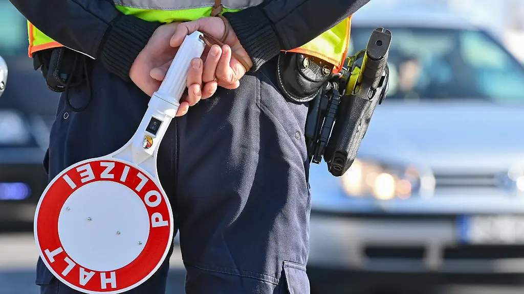 Ein-Polizeibeamter-haelt-eine-Winkerkelle-in-den-Haenden