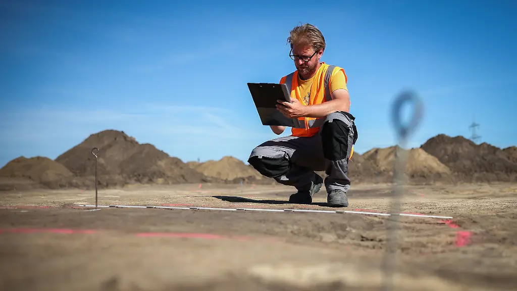 Der-Archaeologe-Nikita-Sirman-vom-Landesamt-fuer-Denkmalpflege-und-Archaeologie-vermisst-und-kartiert-den-Grundriss-eines-Grubenhauses