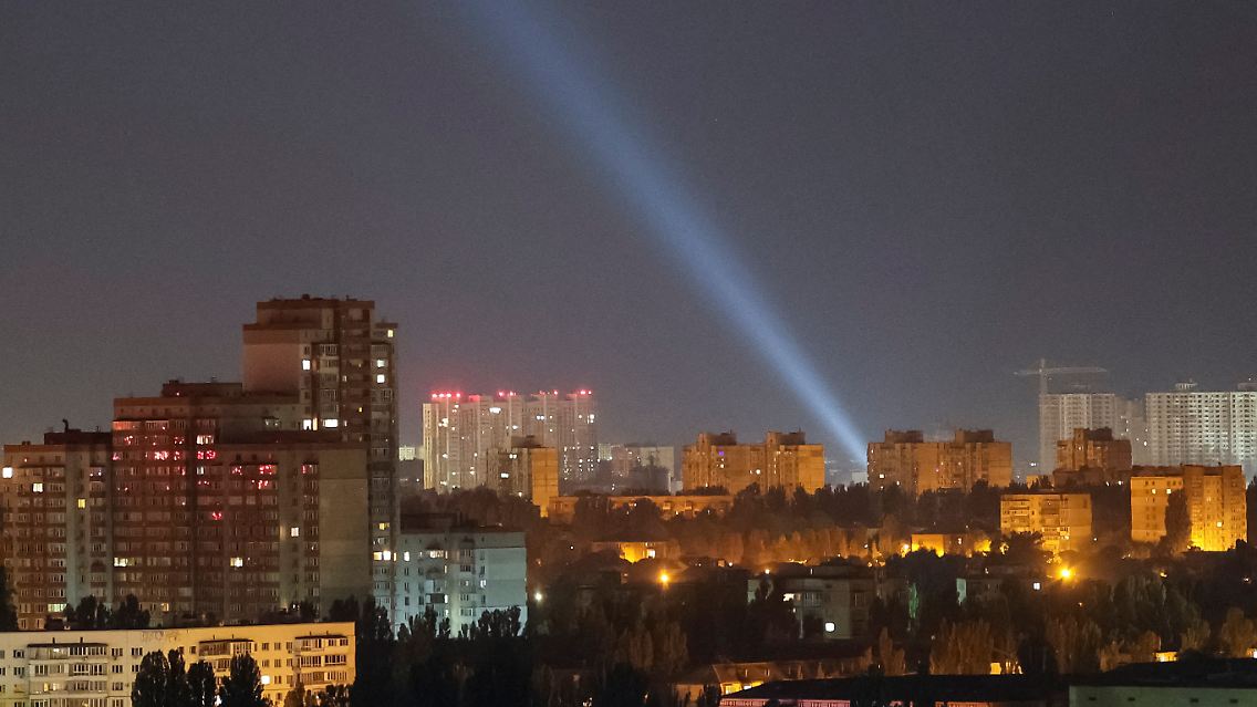 Ukrainische Einsatzkräfte suchen mit Scheinwerfern nach Drohnen am Himmel über dem Kiewer Stadtzentrum.