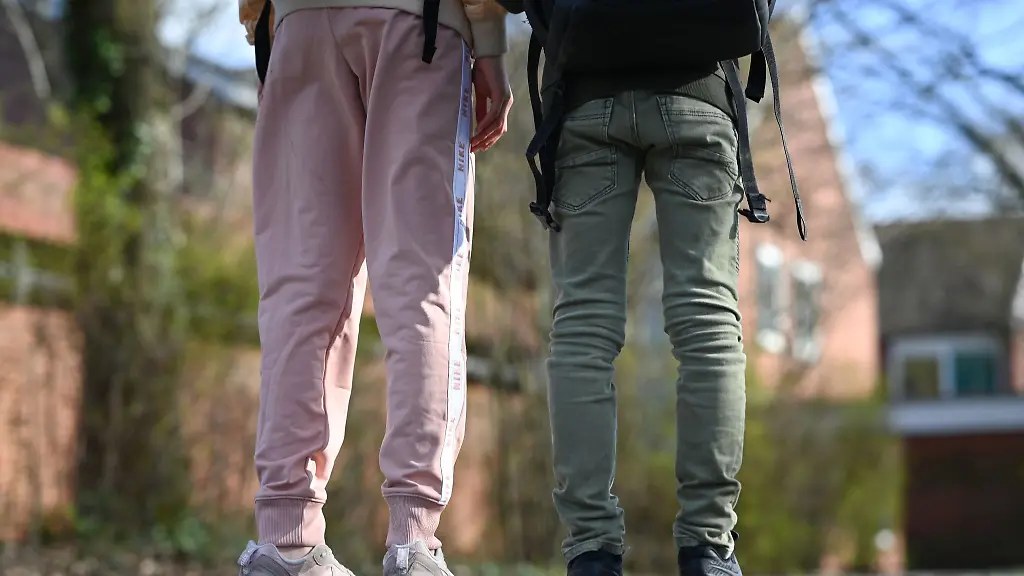 Eine-Schuelerin-mit-einer-Jogginghose-steht-neben-ihrer-Mitschuelerin-die-eine-Jeans-traegt