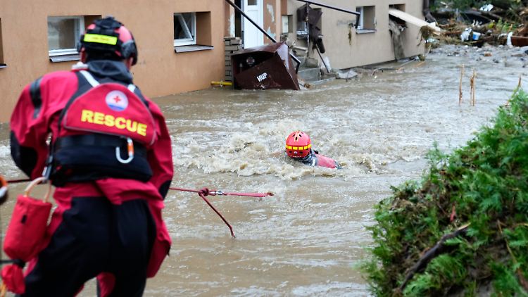Ein Rettungshelfer wird im tschechischen Jesenik bei einer Evakuierungsaktion gegen die starke Strömung gezogen.