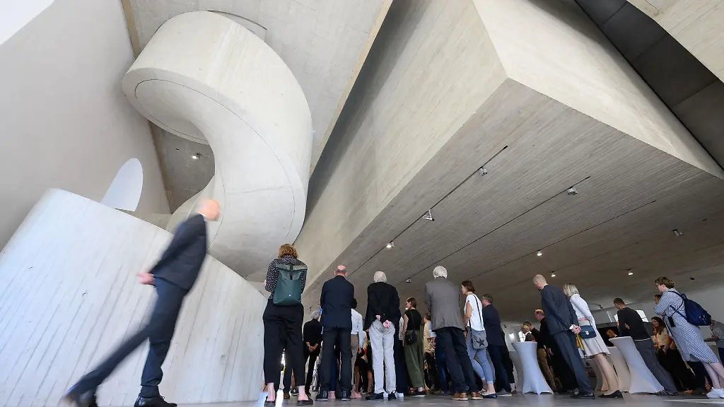 Gaeste-stehen-bei-der-feierlichen-Uebergabe-des-Blockhauses-nach-Umbau-und-Sanierung-zum-Archiv-der-Avantgarden-Egidio-Marzona-in-dem-Gebaeude