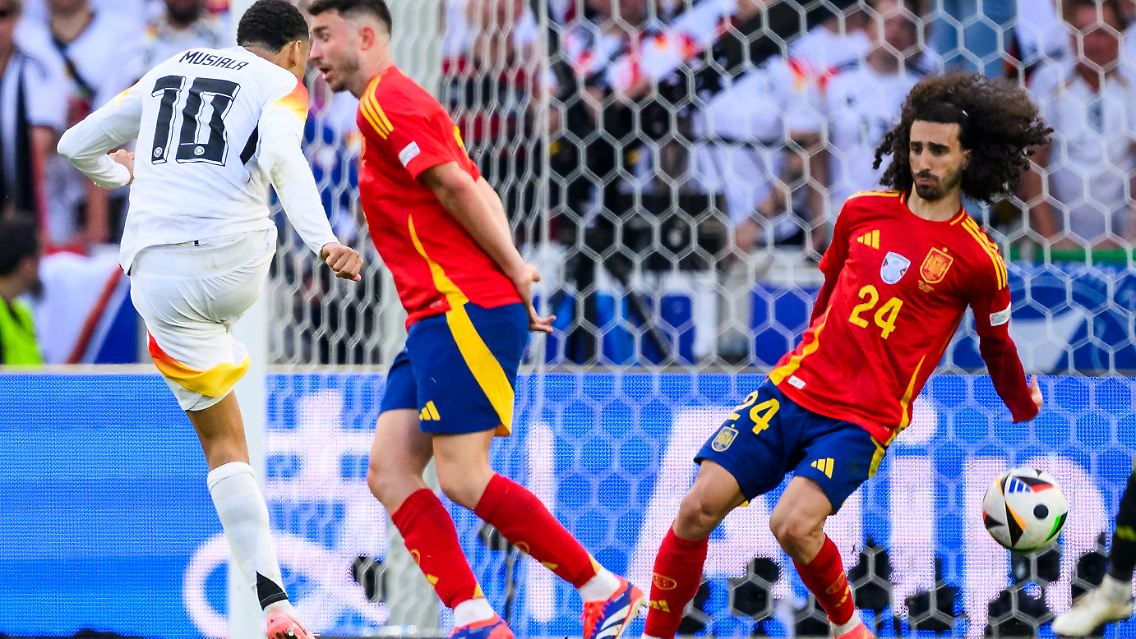 Jamal Musiala schießt, Marc Cucurella wird getroffen.