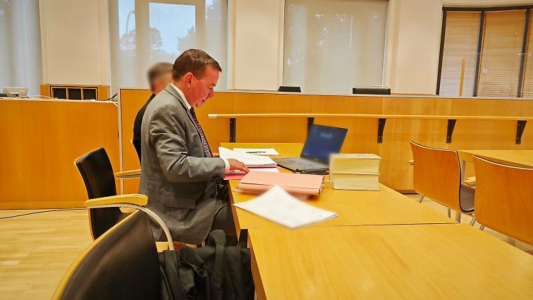 Der angeklagte ehemalige Pfarrer sitzt hinter seinem Anwalt im Landgericht Fulda. 