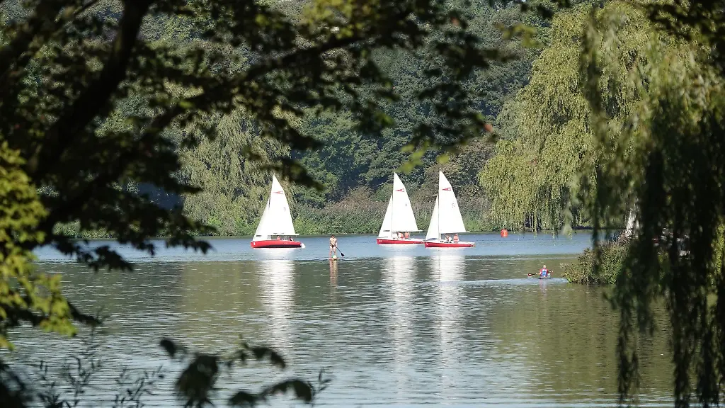 Segelboote-Kajakfahrer-und-ein-Mann-auf-einem-SUP-sind-auf-der-Aussenalster-unterwegs