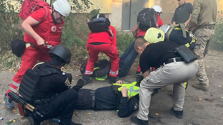 Sanitäter leisten Erste Hilfe für verletzte Mitarbeiter des Rettungsdienstes nach russischen Angriffen auf ein medizinisches Zentrum in der nordostukrainischen Stadt Sumy.