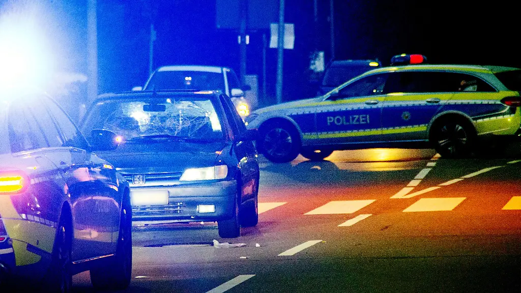 Ein-beschaedigtes-Fahrzeug-und-Polizeiwagen-stehen-an-einem-Zebrastreifen