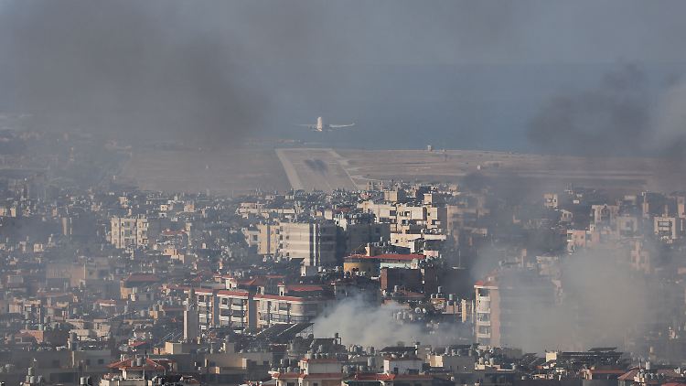 Ein Flugzeug hebt auf dem Beirut-Rafic Hariri International Airport ab, während Rauch nach einem israelischen Angriff aufsteigt.