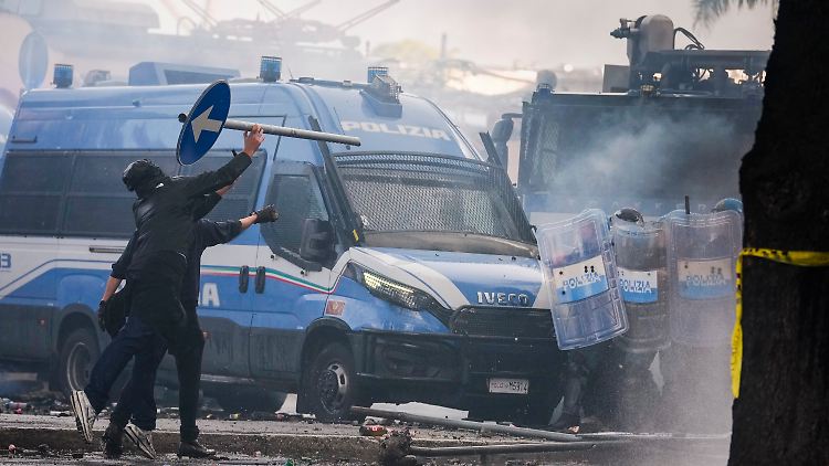 Demonstranten werfen Straßenschilder.