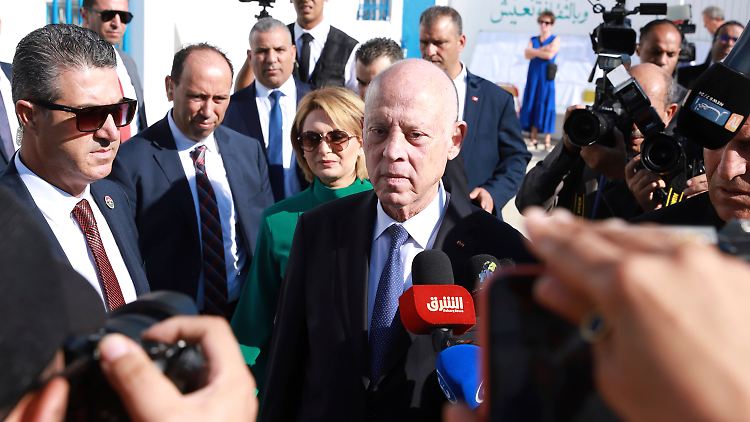 Tunesiens umstrittener Präsident Saied (Mitte) und seine Frau verlassen nach der Stimmabgabe ein Wahllokal in Tunis.