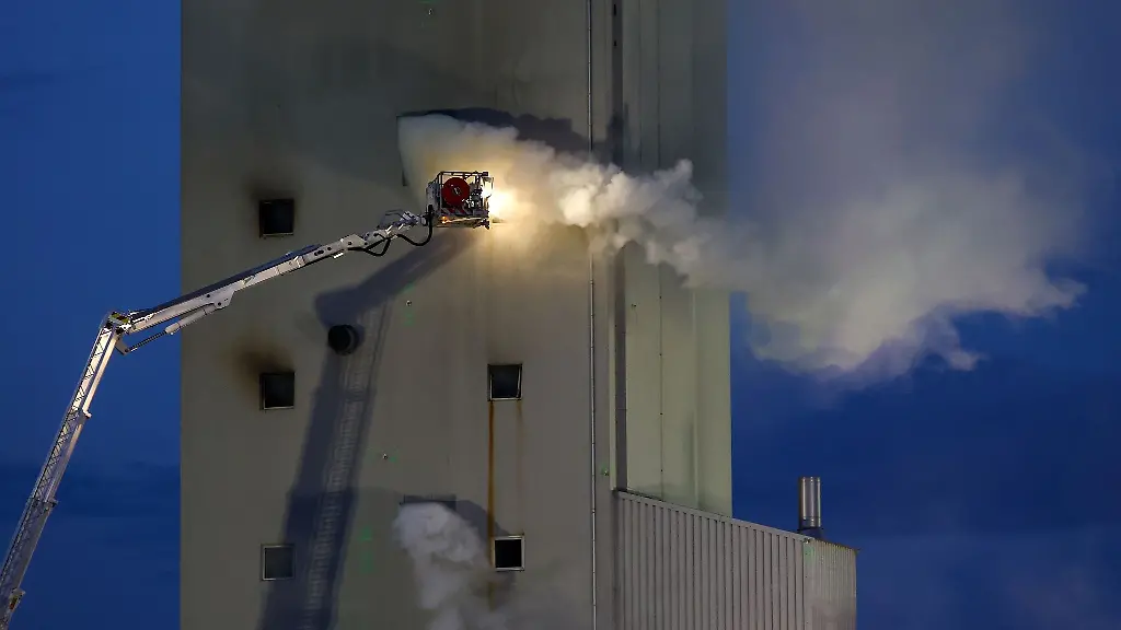 Einsatzkraefte-sind-mit-Loescharbeiten-an-einem-Silo-in-dem-Getreide-gelagert-wird-beschaeftigt