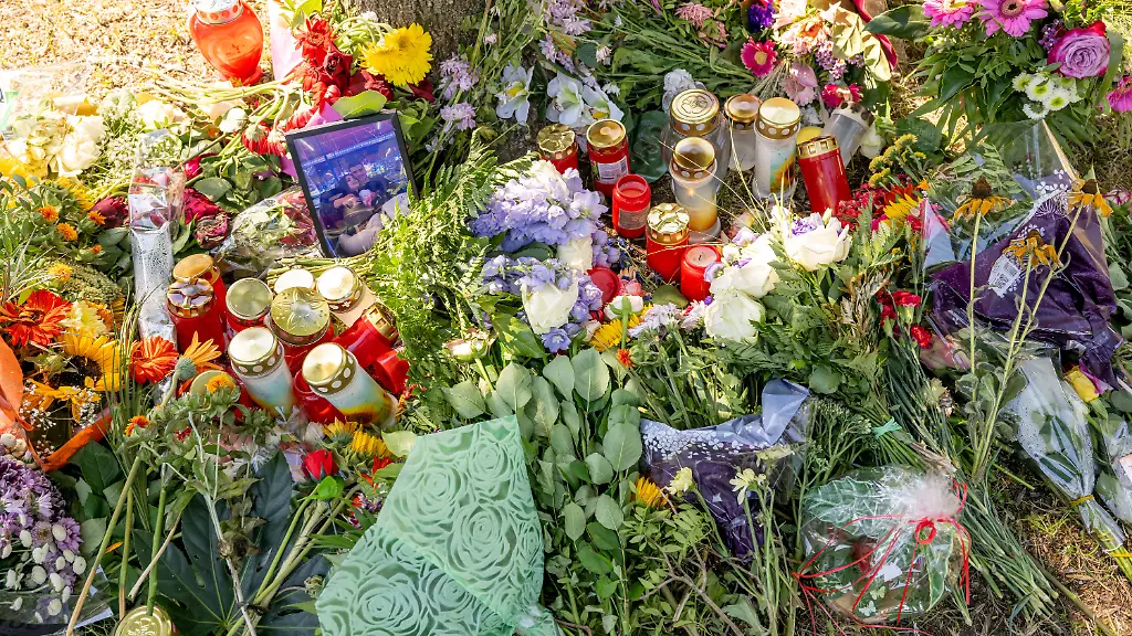 Blumen-Kerzen-und-Bilder-liegen-an-einem-Baum-in-dessen-Naehe-am-17-August-2022-eine-weibliche-Leiche-in-einem-PKW-entdeckt-wurde