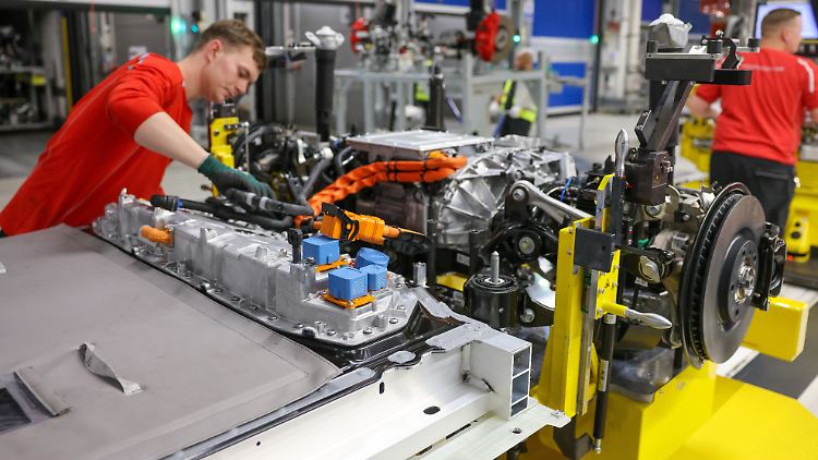 Die Batterie ist das teuerste Bauteil eines Elektroautos - und sie altert. Hier werden Akku und Fahrwerk an einem vollelektrischen Porsche Macan verkabelt.