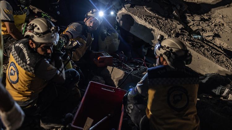 Mitglieder des syrischen Zivilschutzes retten ein Kind, das nach einem russischen Angriff auf den Stadtrand von Idlib unter Trümmern liegt. 