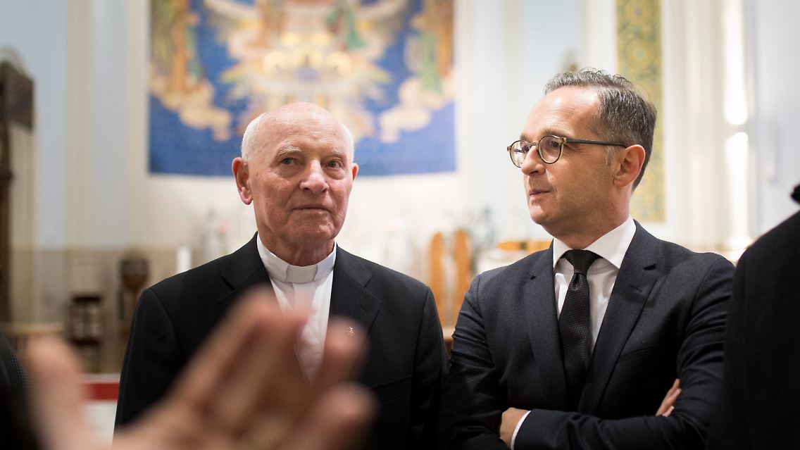 2019: Pater Imre Kozma (l.) spricht in der Kirche zur heiligen Familie in Budapest mit dem damaligen Bundesaußenminister Heiko Maas.