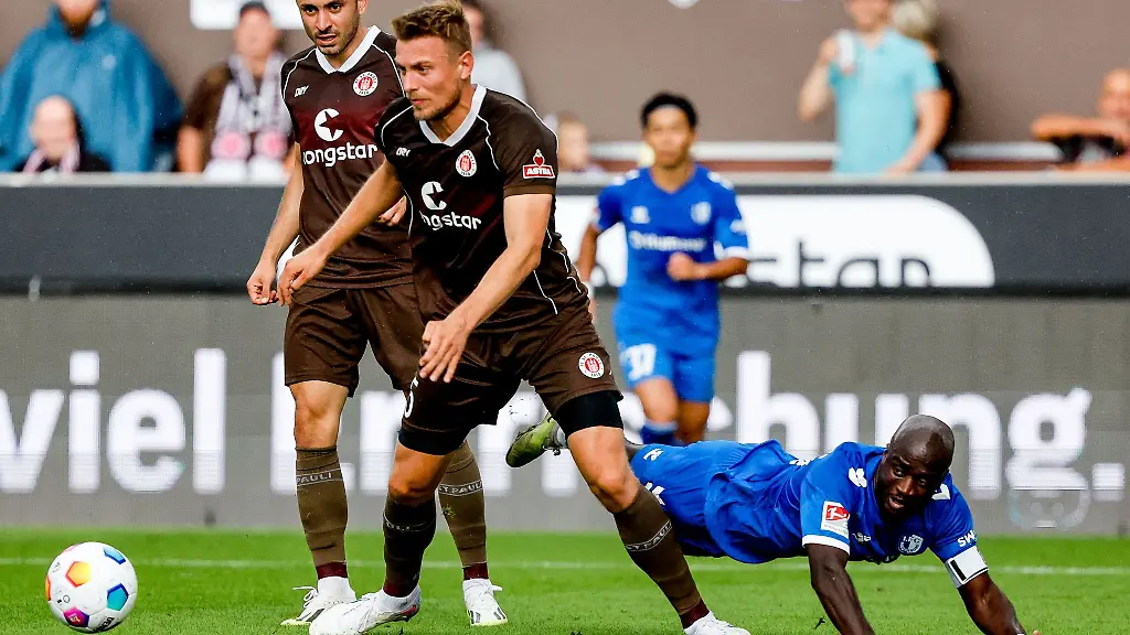 Sankt-Paulis-Manolis-Saliakas-l-r-Sankt-Paulis-Hauke-Wahl-und-Magdeburgs-Amara-Conde-kaempfen-um-den-Ball