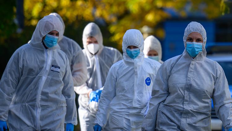 Beamte einer Tatortgruppe untersuchen den Tatort in einem Mehrfamilienhaus in Leipzig.
